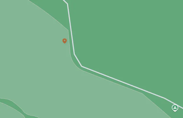 A simplified map showing a trailhead marked with a pin and a camping icon along a trail in a green area, indicating an outdoor or natural setting.